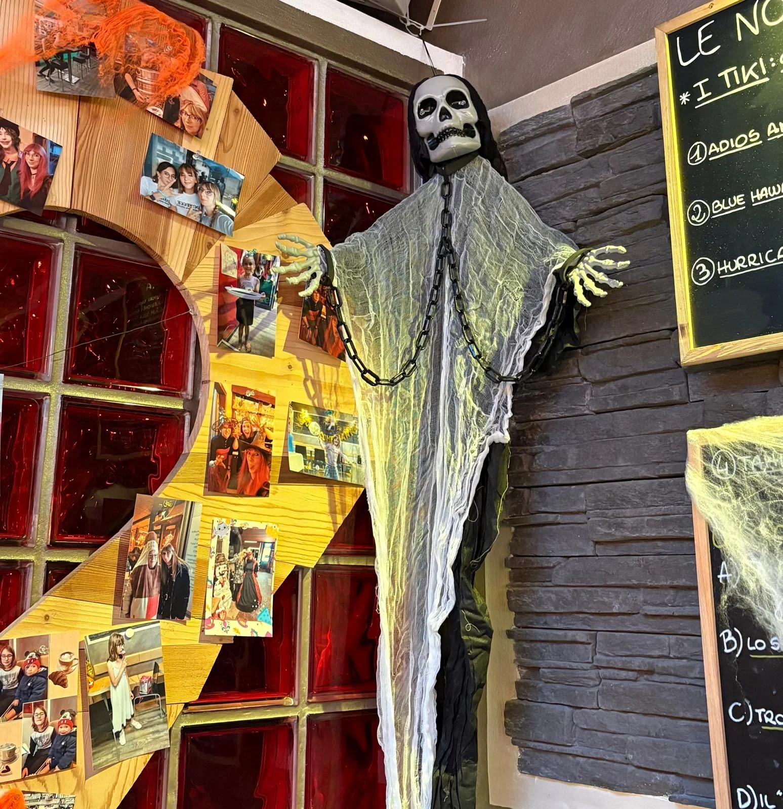 La parete con le foto dei clienti e le decorazioni di Halloween